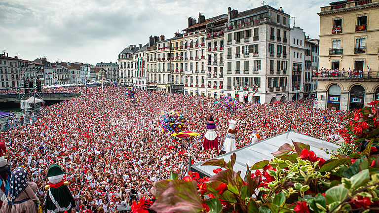 Une marée humaine rouge et blanche déferle sur la place de l'hôtel de ville le jour de l'ouverture des Fêtes.
